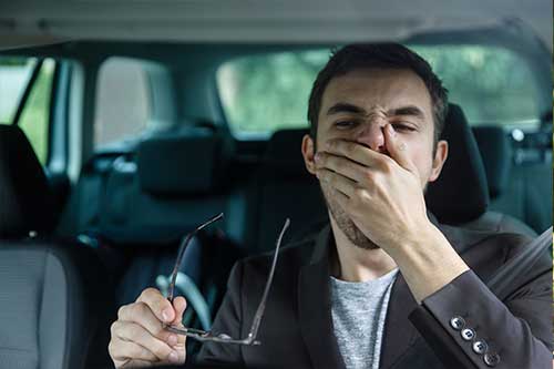tired driver with hand over mouth