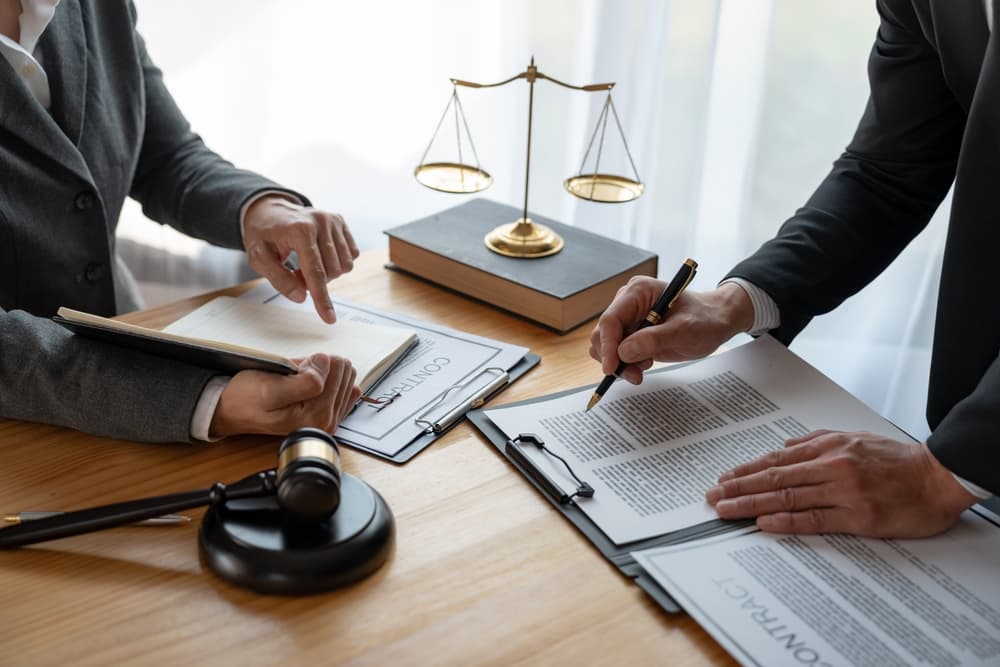 How Can an Attorney Help Me Recover Damages for Pain and Suffering Lawyer or legal advisor reviewing business contract details, ensuring accuracy in legal documents during a brainstorming session.