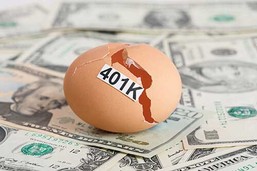 Cracked eggshell labeled “401K” resting on a spread of U.S. dollar bills, symbolizing financial loss or instability in retirement savings.