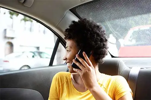 woman in the back of the car talking on the phone