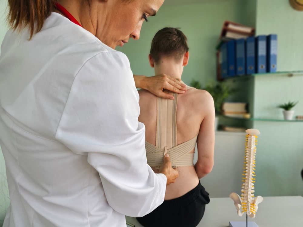 A woman assists a man with back support, demonstrating care and guidance in a supportive environment.